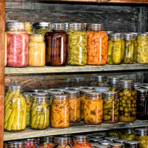 a wooden shelf filled with lots of jars of food
